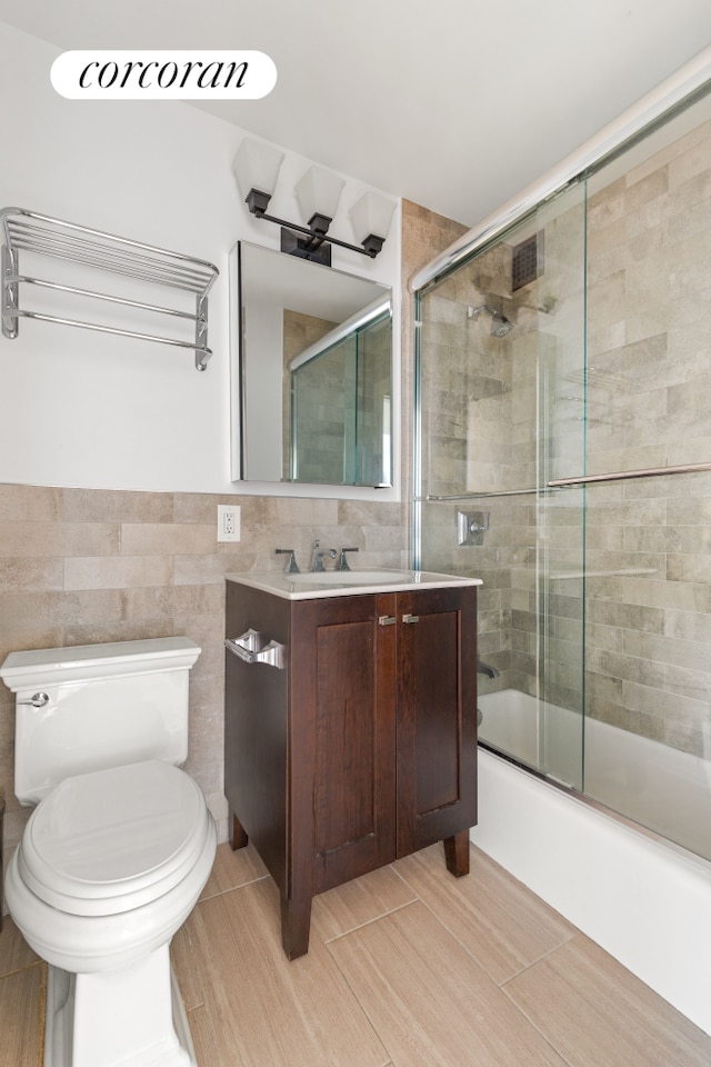 201 E 25th St Unit 9H, New York City, NY 10010 - bathroom with toilet, combined bath / shower with glass door, vanity, and tile walls