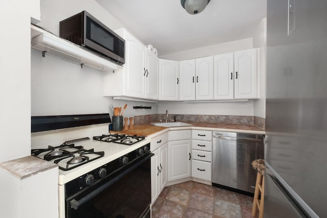 301 E 22nd St Unit 9V, New York City, NY 10010 - kitchen featuring appliances with stainless steel finishes, a sink, white cabinetry, light countertops, and light stone finish flooring