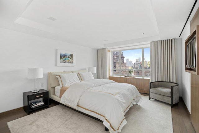 799 Park Ave Unit 19/20B, New York City, NY 10021 - bedroom with light wood finished floors, a tray ceiling, and a view of city