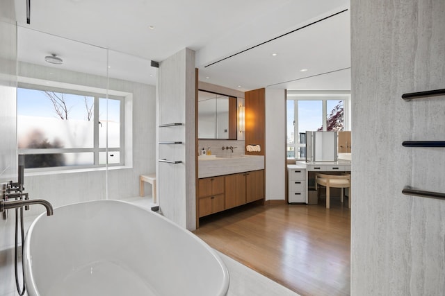 799 Park Ave Unit 19/20B, New York City, NY 10021 - full bathroom featuring wood finished floors, a freestanding tub, vanity, and decorative backsplash
