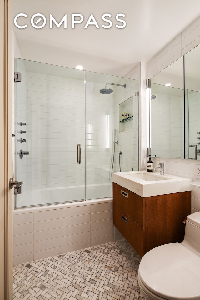 360 W 22nd St Unit 5M, New York City, NY 10011 - bathroom with toilet, tiled shower / bath combo, vanity, and tile walls