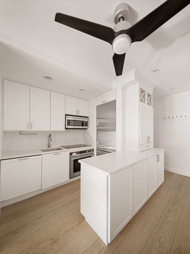 435 E 86th St Unit Gc, New York City, NY 10028 - kitchen featuring appliances with stainless steel finishes, a sink, white cabinetry, and light countertops