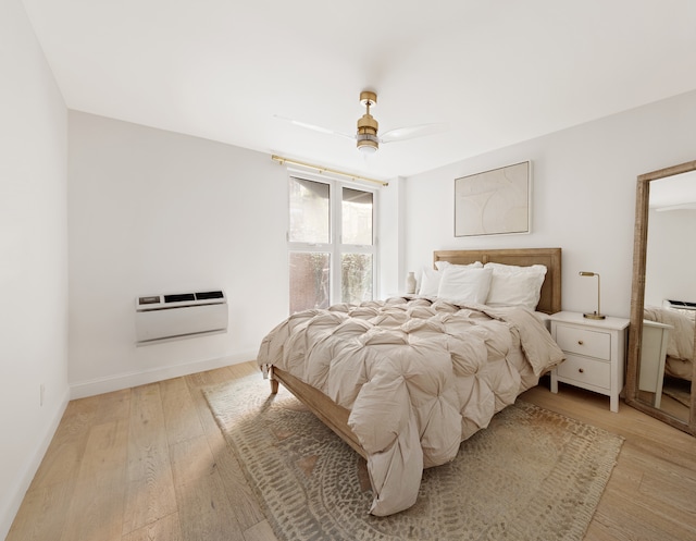 435 E 86th St Unit Gc, New York City, NY 10028 - bedroom with light wood finished floors, a wall unit AC, baseboards, and ceiling fan