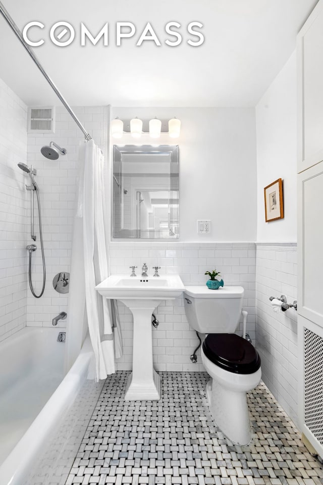 49 E 96th St Unit 4D, New York City, NY 10128 - bathroom featuring shower / bathtub combination with curtain, a wainscoted wall, and tile walls