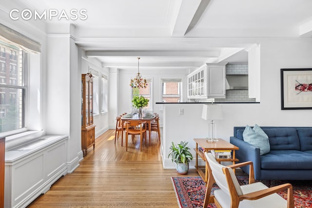 49 E 96th St Unit 4D, New York City, NY 10128 - living room featuring light wood-style flooring, plenty of natural light, a chandelier, and ornamental molding