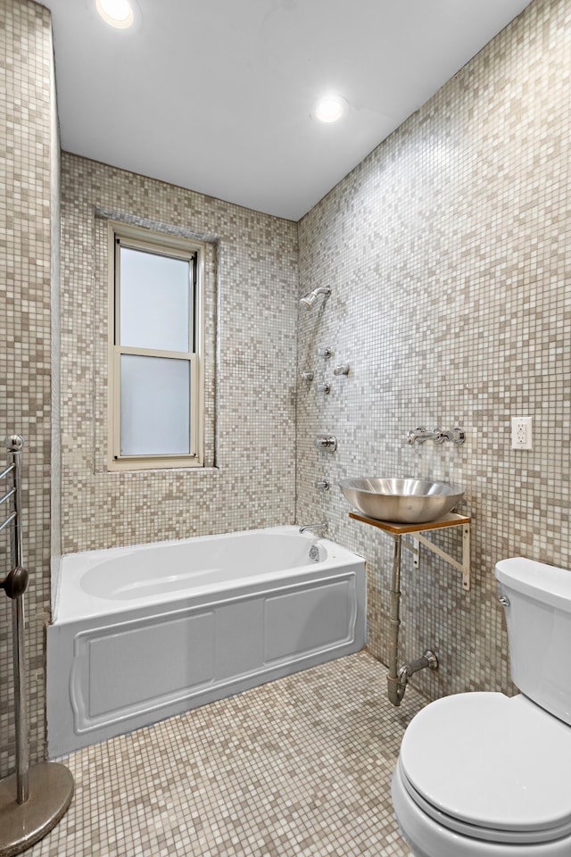 435 Convent Ave Unit 32, New York City, NY 10031 - bathroom featuring tile walls, toilet, a sink, and bathtub / shower combination