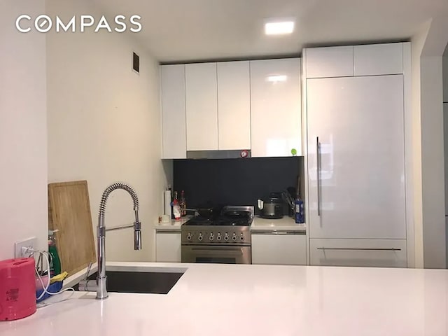 301 W 53rd St Unit 3I, New York City, NY 10019 - kitchen with gas range, a sink, under cabinet range hood, and light countertops