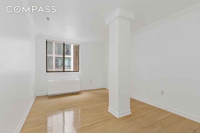 136-140 W 23rd St Unit 4Cc, New York City, NY 10011 - unfurnished room with radiator heating unit, crown molding, light wood-style flooring, and baseboards