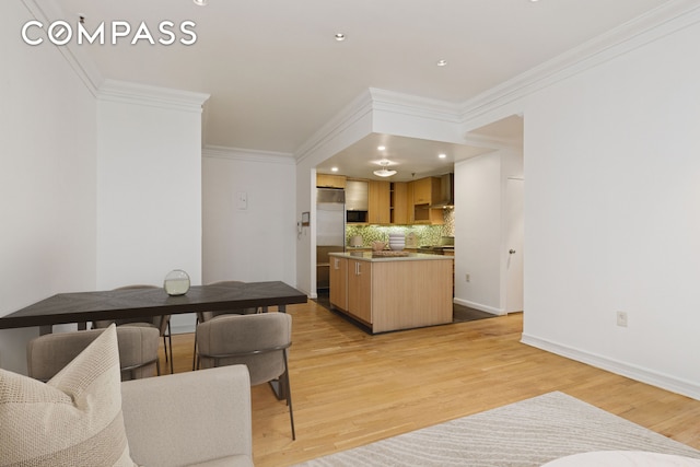 136-140 W 23rd St Unit 4Cc, New York City, NY 10011 - kitchen featuring ornamental molding, tasteful backsplash, high end refrigerator, light wood finished floors, and a center island