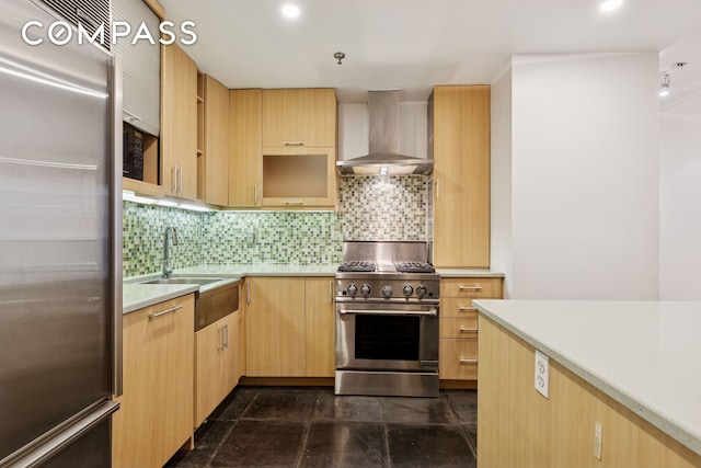 136-140 W 23rd St Unit 4Cc, New York City, NY 10011 - kitchen with high quality appliances, wall chimney range hood, light brown cabinets, decorative backsplash, and light countertops