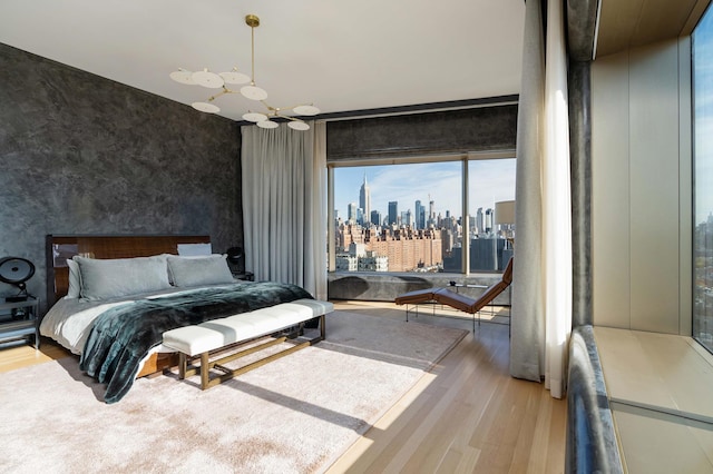551 W 21st St Unit 16-B, New York City, NY 10011 - bedroom featuring a chandelier, wood finished floors, and a skyline view
