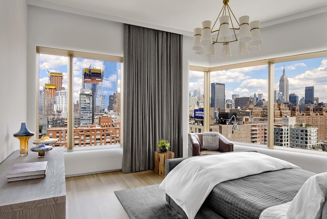 551 W 21st St Unit 16-B, New York City, NY 10011 - bedroom with a skyline view, a chandelier, wood finished floors, and multiple windows