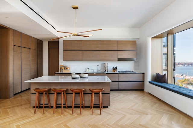551 W 21st St Unit 16-B, New York City, NY 10011 - kitchen with modern cabinets, a breakfast bar, a center island, light countertops, and a sink