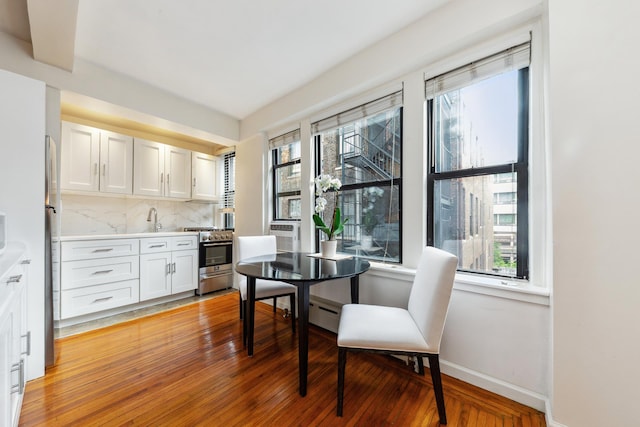 339 E 58th St Unit 7H, New York City, NY 10022 - dining room with baseboards, light wood finished floors, and a baseboard radiator