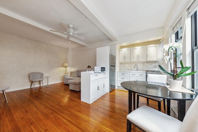 339 E 58th St Unit 7H, New York City, NY 10022 - living room featuring beam ceiling, a ceiling fan, light wood-type flooring, and baseboards