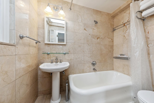 339 E 58th St Unit 7H, New York City, NY 10022 - bathroom featuring tile walls, shower / bathtub combination with curtain, toilet, and a sink