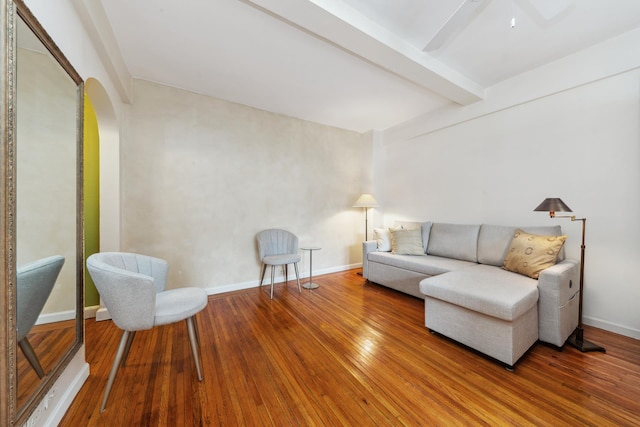339 E 58th St Unit 7H, New York City, NY 10022 - living area featuring beam ceiling, arched walkways, hardwood / wood-style flooring, a ceiling fan, and baseboards