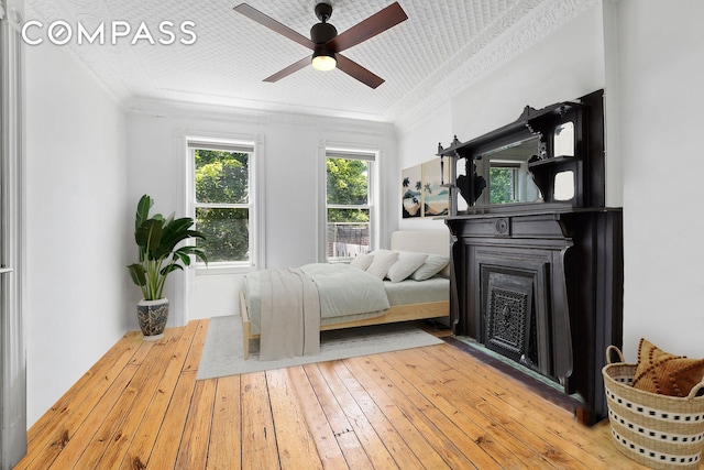 64 Clifton Place, New York City, NY 11238 - bedroom with crown molding, a fireplace, wood-type flooring, and a ceiling fan