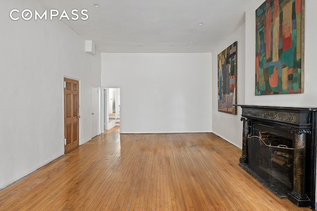 198 6th Ave, New York City, NY 10013 - unfurnished living room with hardwood / wood-style floors, a fireplace, baseboards, and stairs