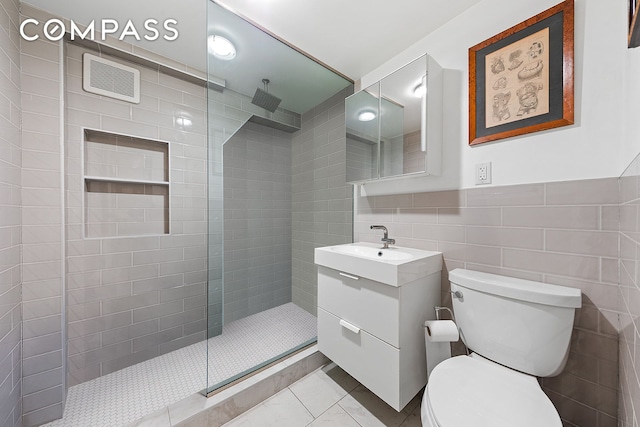 198 6th Ave, New York City, NY 10013 - bathroom with vanity, toilet, a walk in shower, tile walls, and tile patterned flooring
