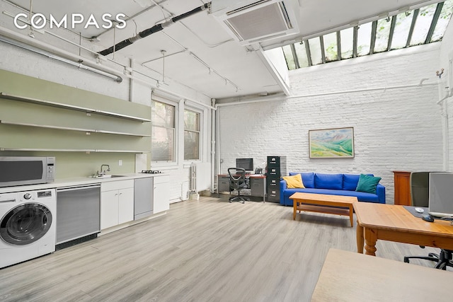 198 6th Ave, New York City, NY 10013 - laundry room featuring washer / clothes dryer, an office area, light wood-style flooring, and a sink