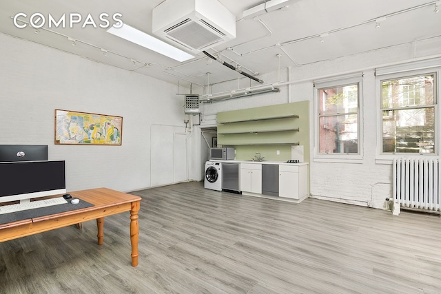 198 6th Ave, New York City, NY 10013 - office area featuring radiator heating unit, light wood-style flooring, and a sink