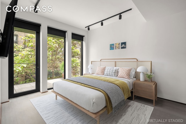 619 E 6th St Unit 4, New York City, NY 10009 - bedroom with track lighting, access to exterior, and wood finished floors