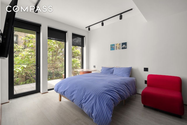 619 E 6th St Unit 4, New York City, NY 10009 - bedroom featuring track lighting, wood finished floors, and access to outside