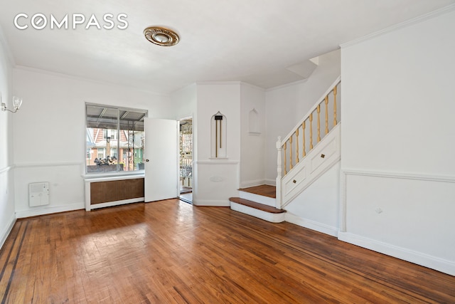 536 E 43rd St, New York City, NY 11203 - unfurnished living room featuring radiator, stairs, wood finished floors, and baseboards