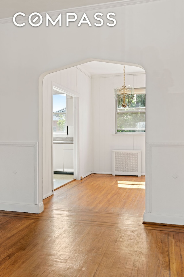 536 E 43rd St, New York City, NY 11203 - spare room with radiator, wood finished floors, and baseboards
