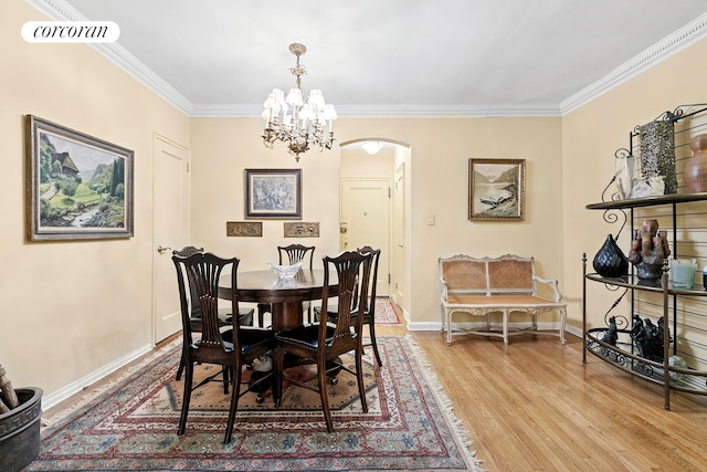 520 E 90th St Unit 2B, New York City, NY 10128 - dining space featuring arched walkways, light wood finished floors, ornamental molding, baseboards, and a chandelier