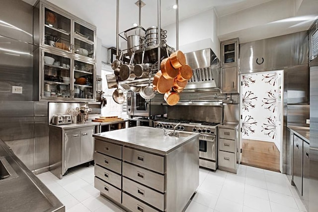 4 E 66th St Unit 4, New York City, NY 10065 - kitchen with stainless steel appliances, backsplash, light tile patterned floors, and extractor fan