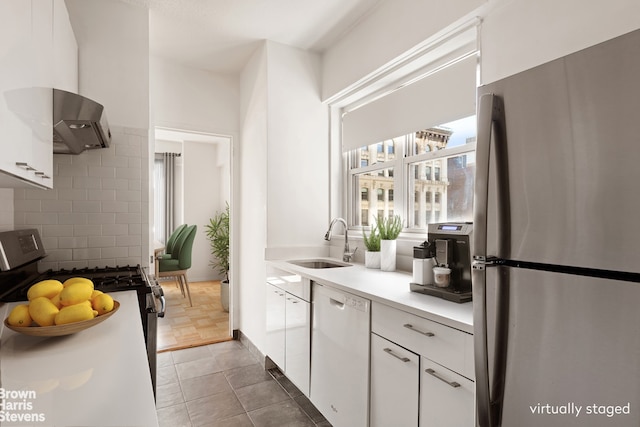 60 E 8th St Unit 12N, New York City, NY 10003 - kitchen with appliances with stainless steel finishes, white cabinetry, range hood, light countertops, and decorative backsplash