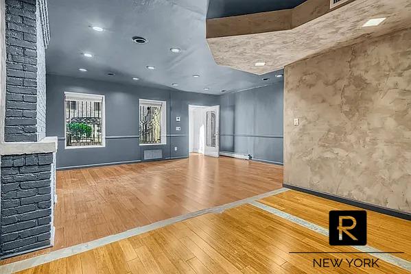 233 E 31st St Unit A, New York City, NY 10016 - unfurnished living room with hardwood / wood-style floors and baseboards