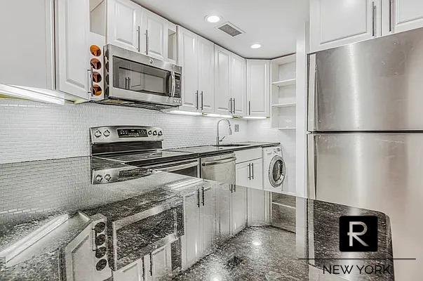 233 E 31st St Unit A, New York City, NY 10016 - kitchen with stainless steel appliances, washer / dryer, white cabinets, a sink, and open shelves