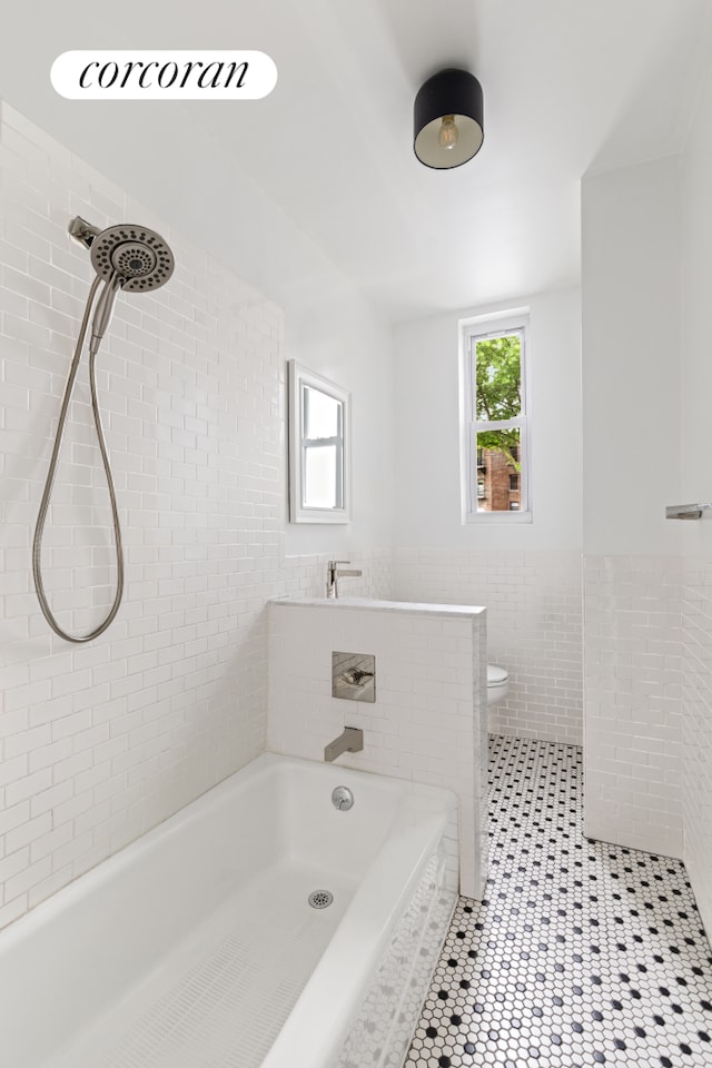 415 9th St Unit 41, New York City, NY 11215 - bathroom featuring tile walls, a tile shower, tile patterned flooring, toilet, and wainscoting
