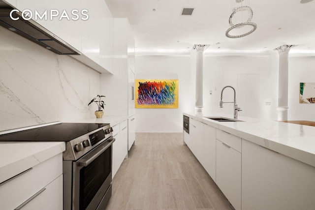 63 Greene St Unit 2D, New York City, NY 10012 - kitchen with electric stove, a sink, white cabinetry, modern cabinets, and light wood-type flooring