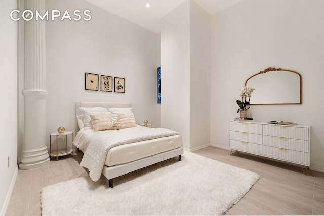 63 Greene St Unit 2D, New York City, NY 10012 - bedroom with light wood-type flooring, baseboards, and decorative columns