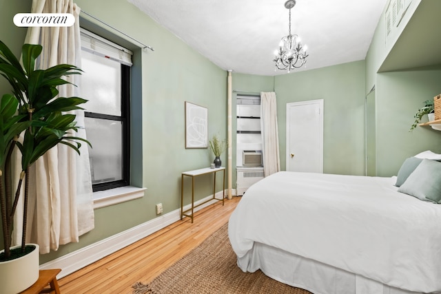 62 E 87th St Unit 1B, New York City, NY 10128 - bedroom featuring wood finished floors, baseboards, and a chandelier