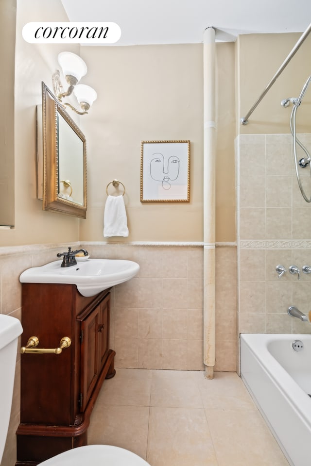 62 E 87th St Unit 1B, New York City, NY 10128 - bathroom featuring tile walls, vanity, washtub / shower combination, tile patterned flooring, and wainscoting