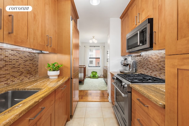 301 E 48th St Unit 6G, New York City, NY 10017 - kitchen with appliances with stainless steel finishes, brown cabinets, light stone counters, and tasteful backsplash