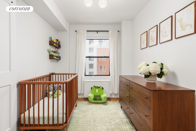 301 E 48th St Unit 6G, New York City, NY 10017 - bedroom featuring a crib and wood finished floors