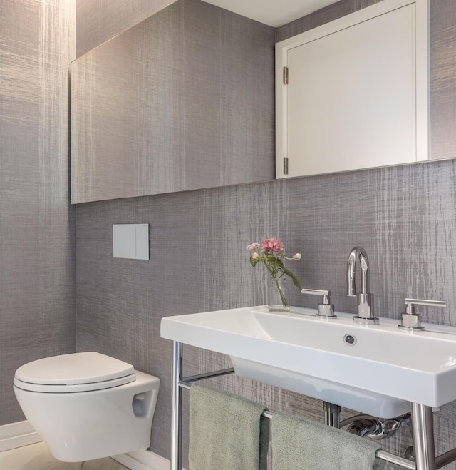 200 E 59th St Unit 15A, New York City, NY 10022 - bathroom featuring toilet, decorative backsplash, a sink, and tile walls