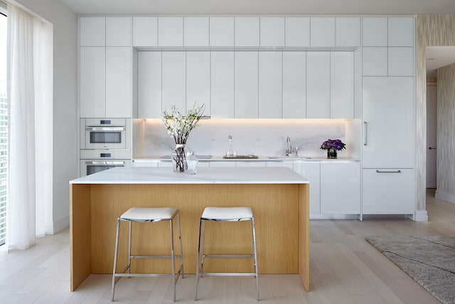200 E 59th St Unit 26D, New York City, NY 10022 - kitchen with modern cabinets, a center island, and backsplash