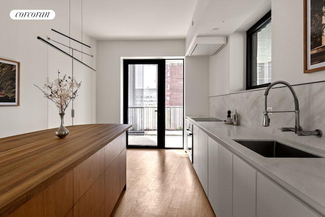 9 Chapel St Unit 9A, New York City, NY 11201 - kitchen with a sink, light wood-style flooring, modern cabinets, tasteful backsplash, and black electric stovetop