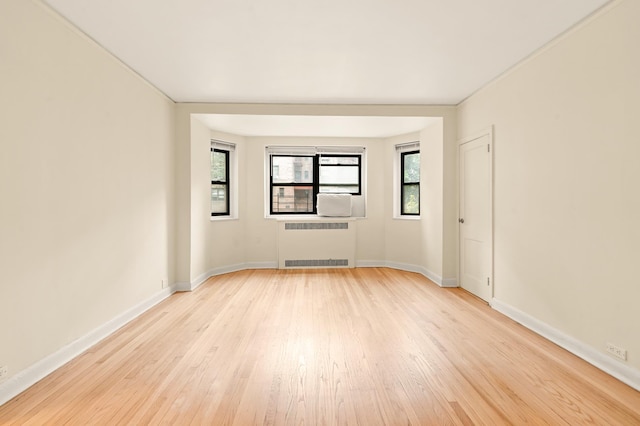 34-21 78th St Unit 1-H, New York City, NY 11372 - spare room with radiator heating unit, light wood-type flooring, and baseboards