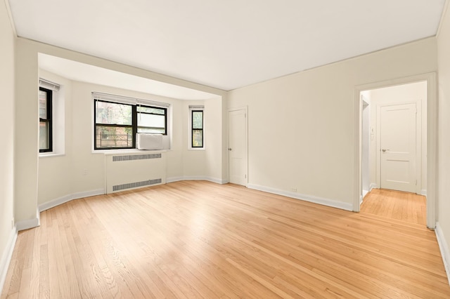 34-21 78th St Unit 1-H, New York City, NY 11372 - spare room featuring radiator heating unit, light wood finished floors, and baseboards