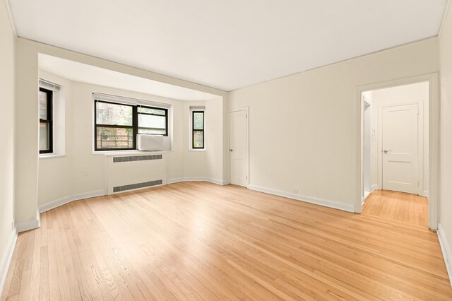 34-21 78th St Unit 1-H, New York City, NY 11372 - unfurnished room with radiator heating unit and light wood finished floors