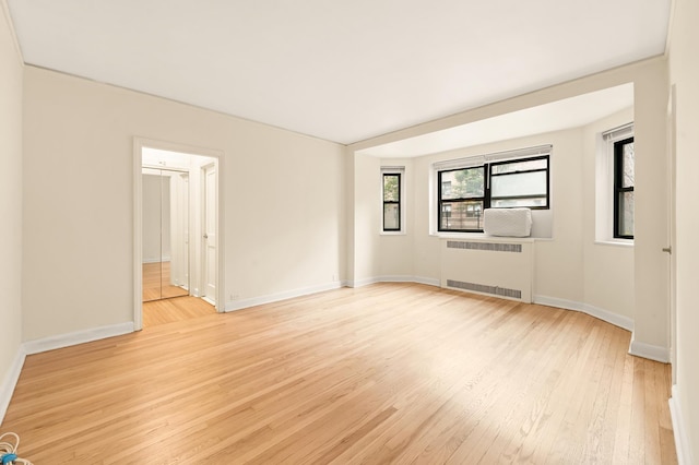 34-21 78th St Unit 1-H, New York City, NY 11372 - empty room featuring radiator heating unit, light wood-type flooring, and baseboards