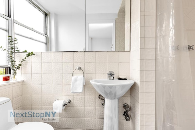 1175 York Ave Unit 16J, New York City, NY 10065 - bathroom featuring tile walls, toilet, and a shower with shower curtain